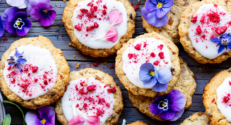 Beautiful array of herbal lactation cookies decorated with pink and purple edible flowers