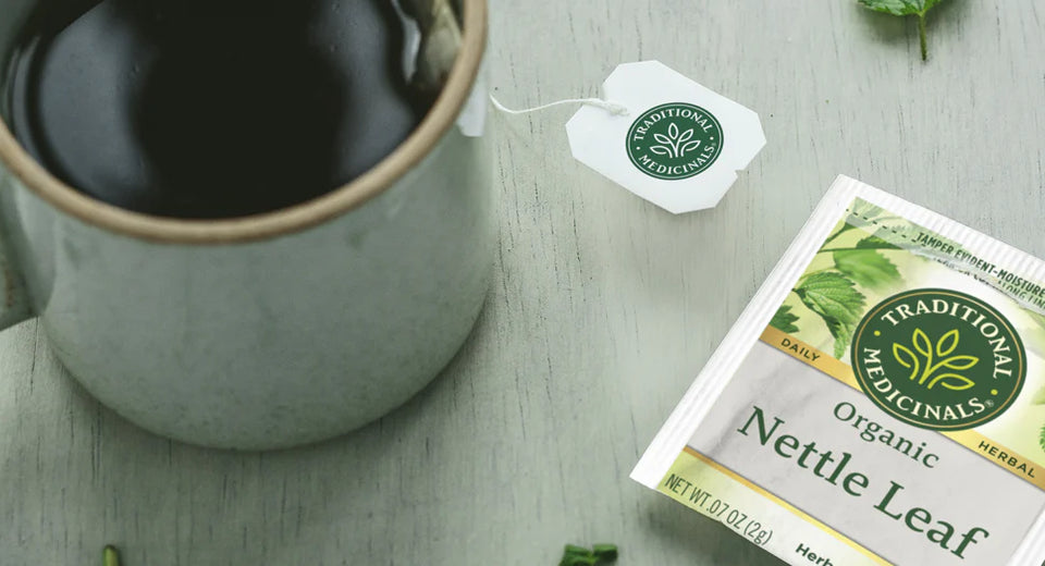 Cup of steeping Nettle Leaf tea next to a Nettle Leaf tea overwrap