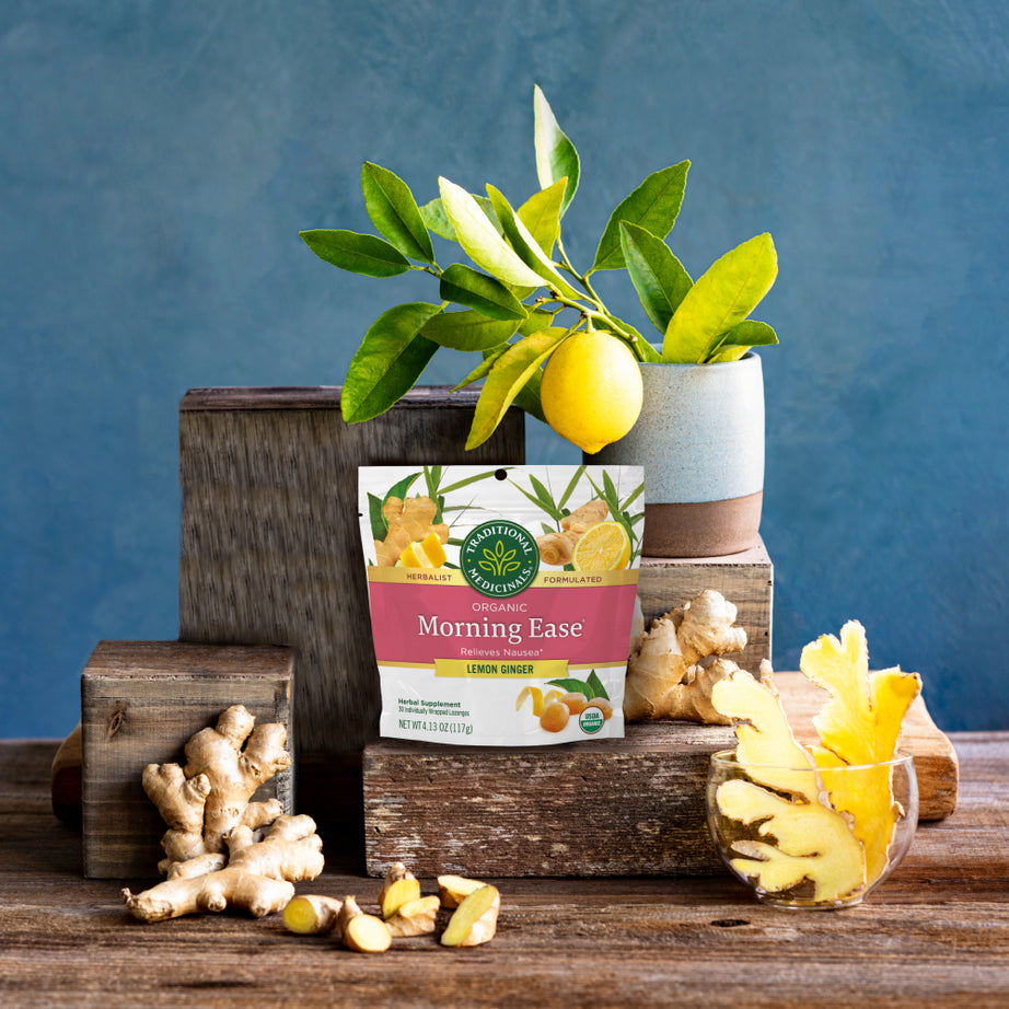 Pack of Morning Ease® Lemon Ginger Lozenges resting on a wooden surface against a blue background. View 2