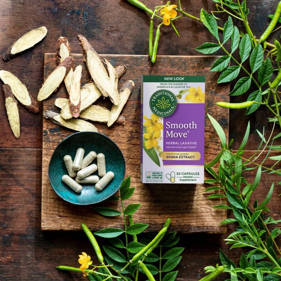 A box of Smooth Move® Capsules, providing natural constipation relief with senna-based herbs and leaves, is elegantly displayed on a wooden surface. View 2